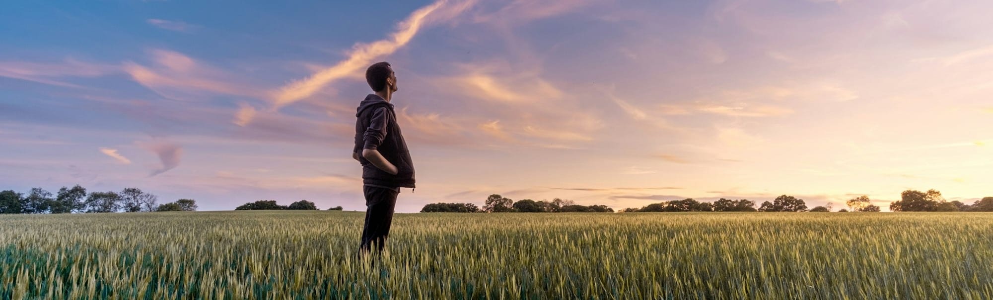man on grass field looking at sky